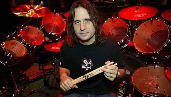 Dave Lombardo com baquetas, diante de sua bateria